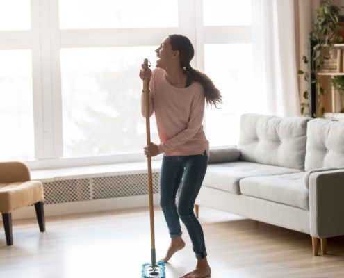 Cary Prince Organizing Your Cleaning Supplies with multiracial girl dancing in living room with broom, and singing into handle as if a microphone