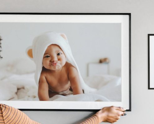 Mother hanging kids photo gallery wall