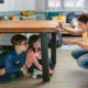 Emergency and Earthquake Preparedness Safety Drill as Mother guides her children under the table